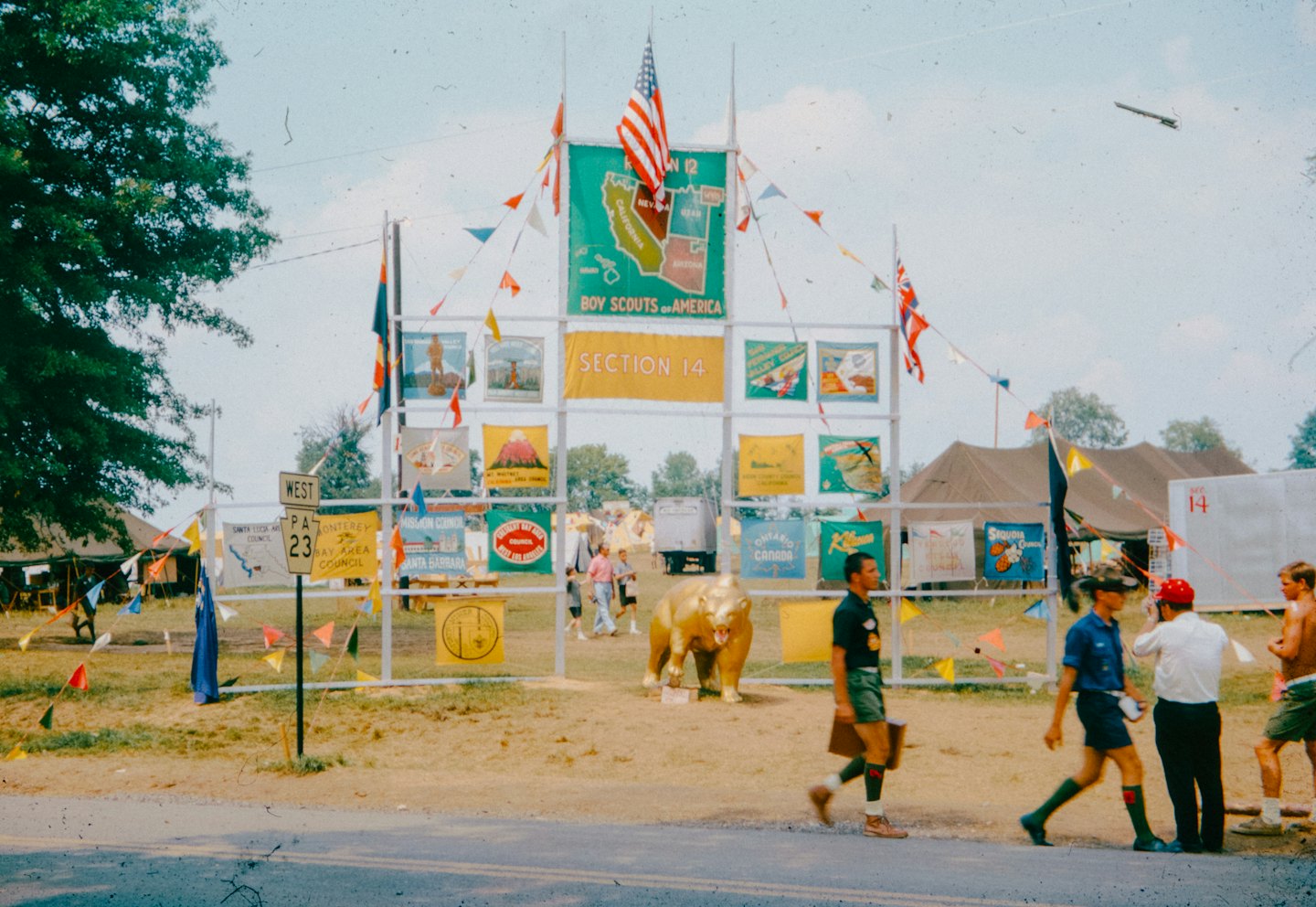 Scouts and adults walk through a decorated event gateway.