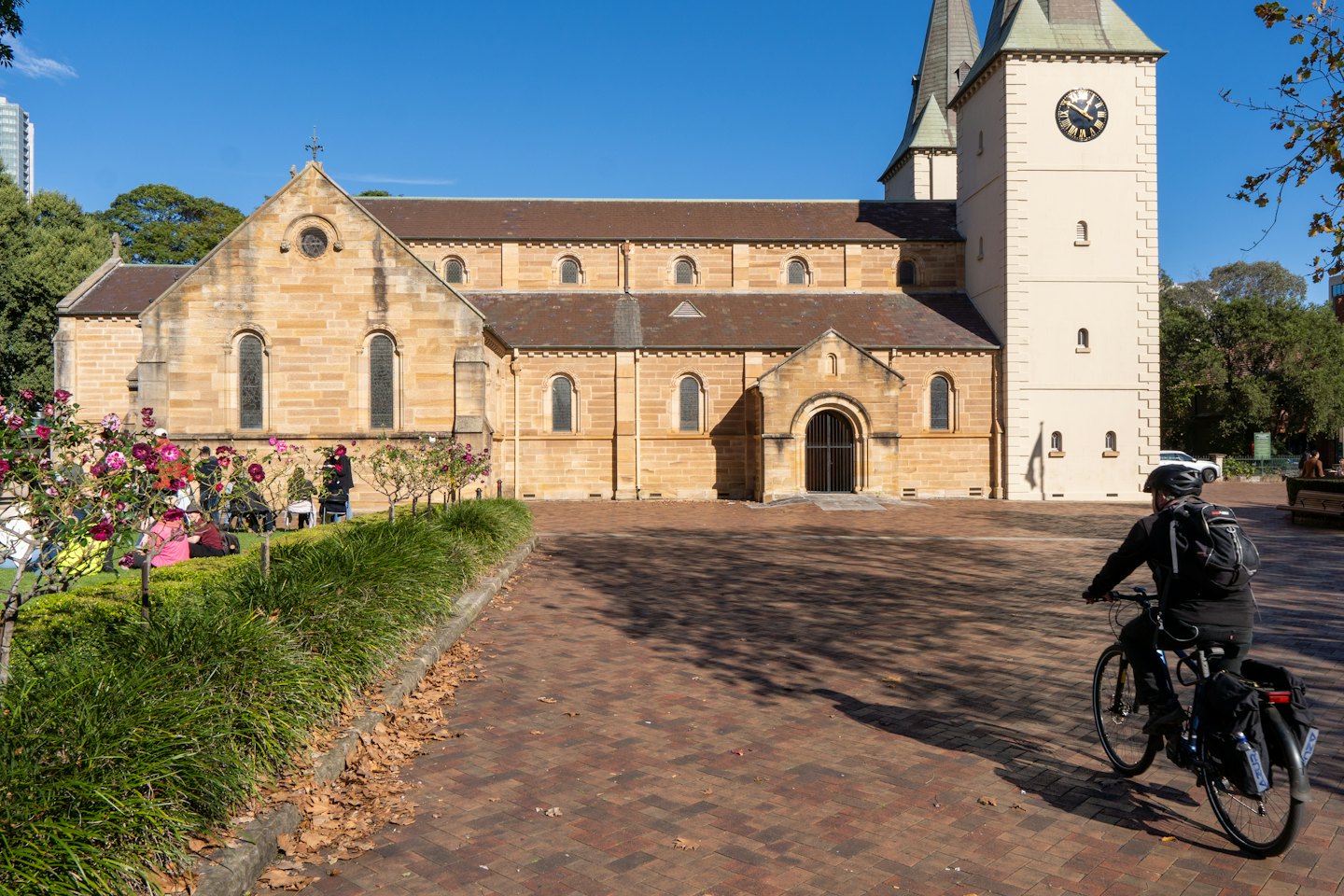 Sandstone church with clock tower and arched windows on a sunny day.